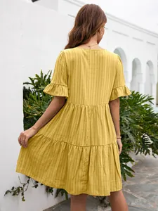 Back view of yellow tiered summer dress with ruffle sleeves and textured fabric.