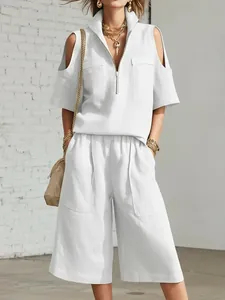 Detalle del conjunto de dos piezas blanco con hombros descubiertos y cuello de cremallera
