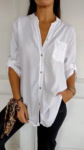 Front view of white loose casual blouse featuring a shimmering sequin pocket detail