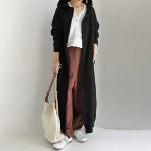 Full-length view of women's long hooded zip-up sweatshirt coat in a black minimalist style