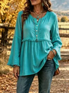 Detail shot of casual turquoise V-neck long sleeve blouse with elegant fringe trim