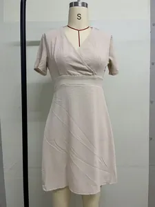 Vista frontale di un abito beige con scollo a V stile francese esposto su un manichino