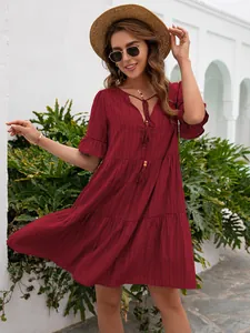 Detailed view of a wine red casual V-neck tiered dress with ruffle sleeves and tassels