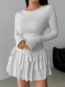 Detailed view of white slim-fit long-sleeved dress with elegant tiered ruffle skirt