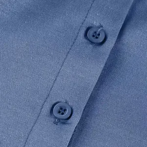 Macro view of blue fabric texture and matching buttons on a casual denim dress