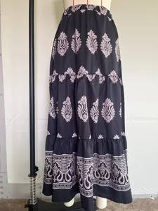 Close-up detail of Bohemian floral patterns on a black tiered high-waist maxi skirt.