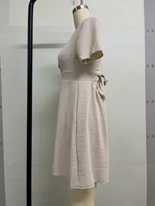 Vista laterale di abito beige stile francese con scollo a V e fiocco sul retro.