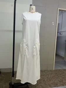 Elegant white sleeveless maxi dress with functional front pockets and a minimalist A-line silhouette.