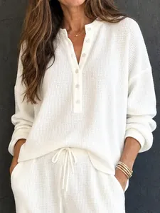 Dettaglio di set bianco in maglia a nido d'ape con maglia a maniche lunghe e pantaloni.