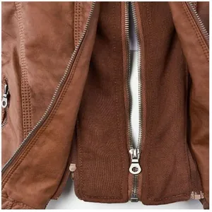 Detailed macro view of the metal zipper and brown faux leather texture on a jacket
