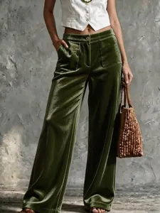 Vue détaillée du pantalon en velours vert à jambes larges avec taille haute et poches.