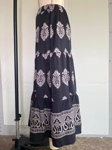 Macro view showing the pink floral pattern on a black Bohemian tiered maxi skirt