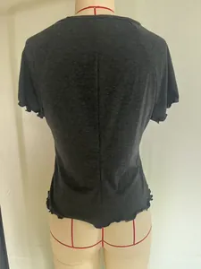 Detail view of dark grey T-shirt featuring back center seam and ruffled hemline
