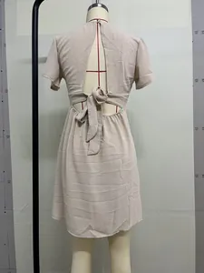 Vista dettagliata del design aperto sulla schiena con fiocco sul vestito estivo beige