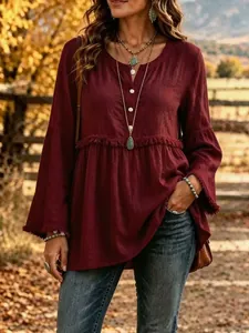 Stylish burgundy long sleeve V-neck blouse featuring fringe details and button accents.