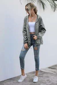 Outdoor lifestyle view of a lightweight sage green hooded windbreaker for women