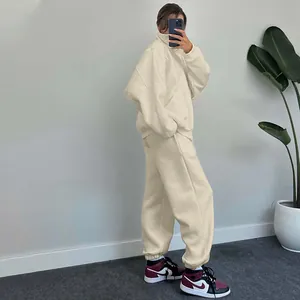 Side view showing a woman wearing a beige oversized fleece tracksuit set for winter