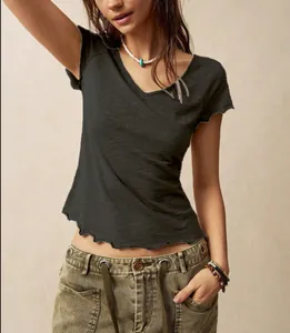 Detail of bohemian V-neck T-shirt with wavy lettuce hem in dark grey textured fabric.