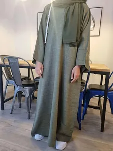 Detail view of olive green loose-fitting Abaya robe with textured fabric and button detail