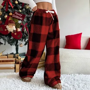 Close-up of red and black buffalo plaid fleece wide-leg lounge pants for women at home