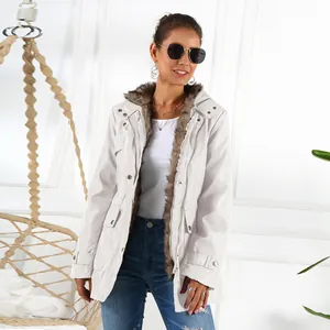Detailed view of women's white mid-length winter parka with lush faux fur collar and lining