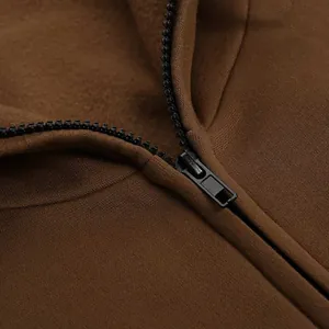 Macro view of black zipper and warm fleece lining on a brown sports hoodie jacket.