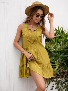 Modelo con vestido de verano amarillo mostaza sin mangas con encaje y borlas