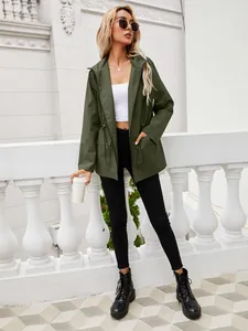 Donna che indossa una giacca a vento verde oliva con cappuccio, coulisse in vita e zip
