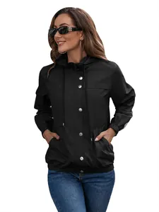 Nahaufnahme eines schwarzen Damen-Windbreakers mit Kapuze und silbernen Druckknöpfen.