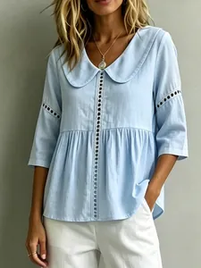 Detailansicht einer hellblauen Bluse mit Peter-Pan-Kragen und feiner Lochspitze