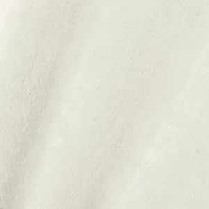 Gros plan sur la texture douce de la fausse fourrure blanche pour manteaux d'hiver.