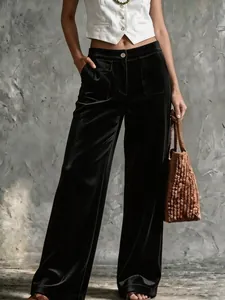 Détail d'un pantalon en velours noir à taille haute et poches avant porté par un mannequin.
