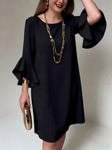 Elegante vestido negro con mangas de volantes y detalles de estilo con joyas doradas