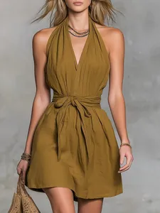 Close-up of olive green halter V-neck dress featuring a waist tie and textured fabric