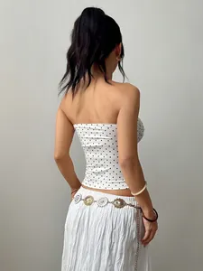 Rückansicht eines weißen Tube-Tops mit schwarzen Punkten, zeigt eine schmale Passform.
