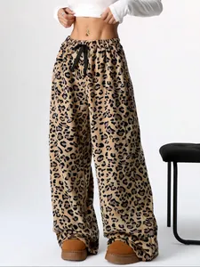 Detail of leopard print wide-leg trousers with soft fleece texture and drawstring waist.