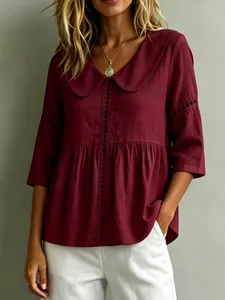 Detailansicht einer weinroten Baumwoll-Leinen-Bluse mit Bubikragen und Lochspitze.