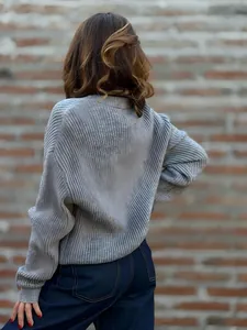 Rückansicht eines grauen Rippstrickpullovers mit detaillierter Textur und Passform.