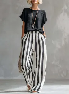 Una vista completa del elegante conjunto de top negro y pantalón a rayas set.