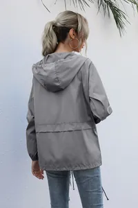 Detail view of grey women's hooded windbreaker featuring back design and adjustable waist.