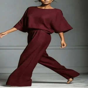 Detail of elegant burgundy linen set featuring bell sleeves and wide-leg trousers