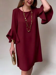 Vista detallada de vestido burdeos elegante con mangas acampanadas y joyas doradas.