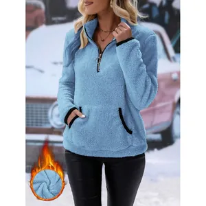 Detail eines blauen Fleece-Hoodies für Damen mit Reißverschluss und weicher Plüschtextur.