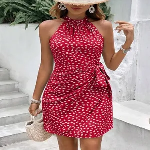 Dettaglio di abito halter rosso a fiori bianchi con cintura a fiocco in vita.