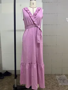 Detalle de un vestido largo violeta sin mangas con cuello en V, volantes y cinturón.