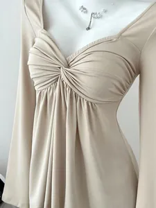 Détail du haut beige col en V manches longues femme avec un nœud croisé sur le devant