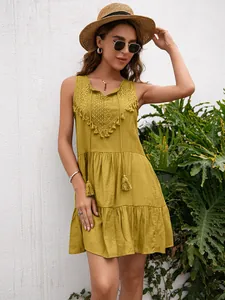 Detalle de vestido sin mangas amarillo mostaza con encaje y borlas