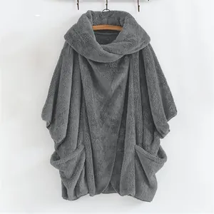 Dettaglio di un poncho grigio in pile oversize con collo ampio e comode tasche