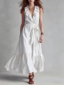 Detalle de un vestido largo blanco sin mangas con cuello en V con volantes y lazo en cintura
