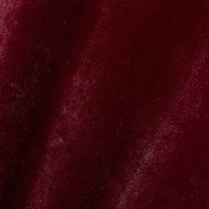 Vue macro montrant la texture douce et l'éclat soyeux de la fausse fourrure bordeaux